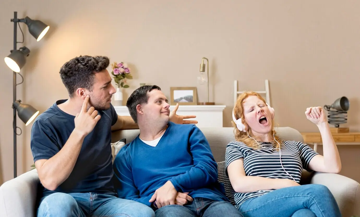 Mujer cantando en voz alta junto a sus amigos mientras lleva puestos auriculares.